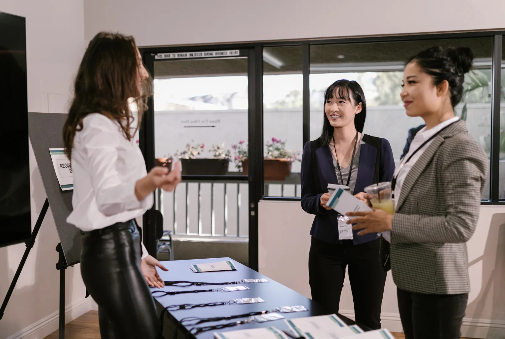 Three team members smiling behind a registration desk at an event stand